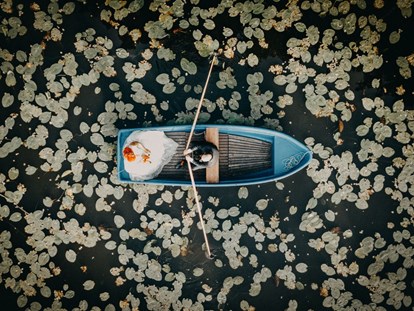 Hochzeitsfotos - Groß Plasten - Paarshooting auf einem Boot mitten in einem Seerosenfeld. Das Aftershooting mit dem Brautpaar wurde mit einer Drohne aus der Luft aufgenommen. - Fotograf David Kohlruss
