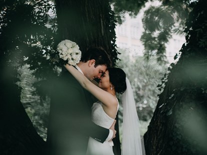 Hochzeitsfotos - zweite Kamera - Hochzeitsfotos mit Fotoshooting am Gendarmenmarkt Berlin. Die Braut un der Bräutigam unter einem Baum. - Fotograf David Kohlruss
