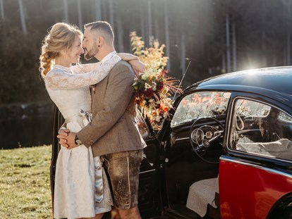 Hochzeitsfotos - Berufsfotograf - Bad Reichenhall - Brautpaar vor einem schwarzen Oldtimer - Facetten Fotografie