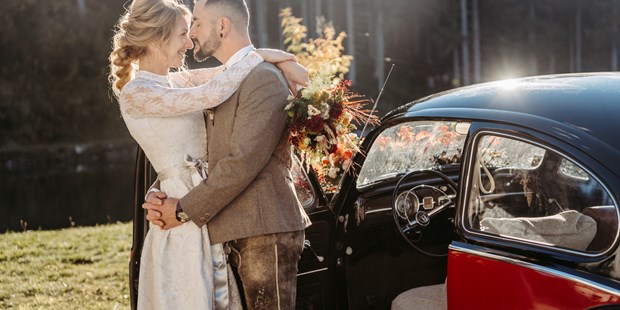 Hochzeitsfotos - Copyright und Rechte: Bilder auf Social Media erlaubt - Oberbayern - Brautpaar vor einem schwarzen Oldtimer - Facetten Fotografie