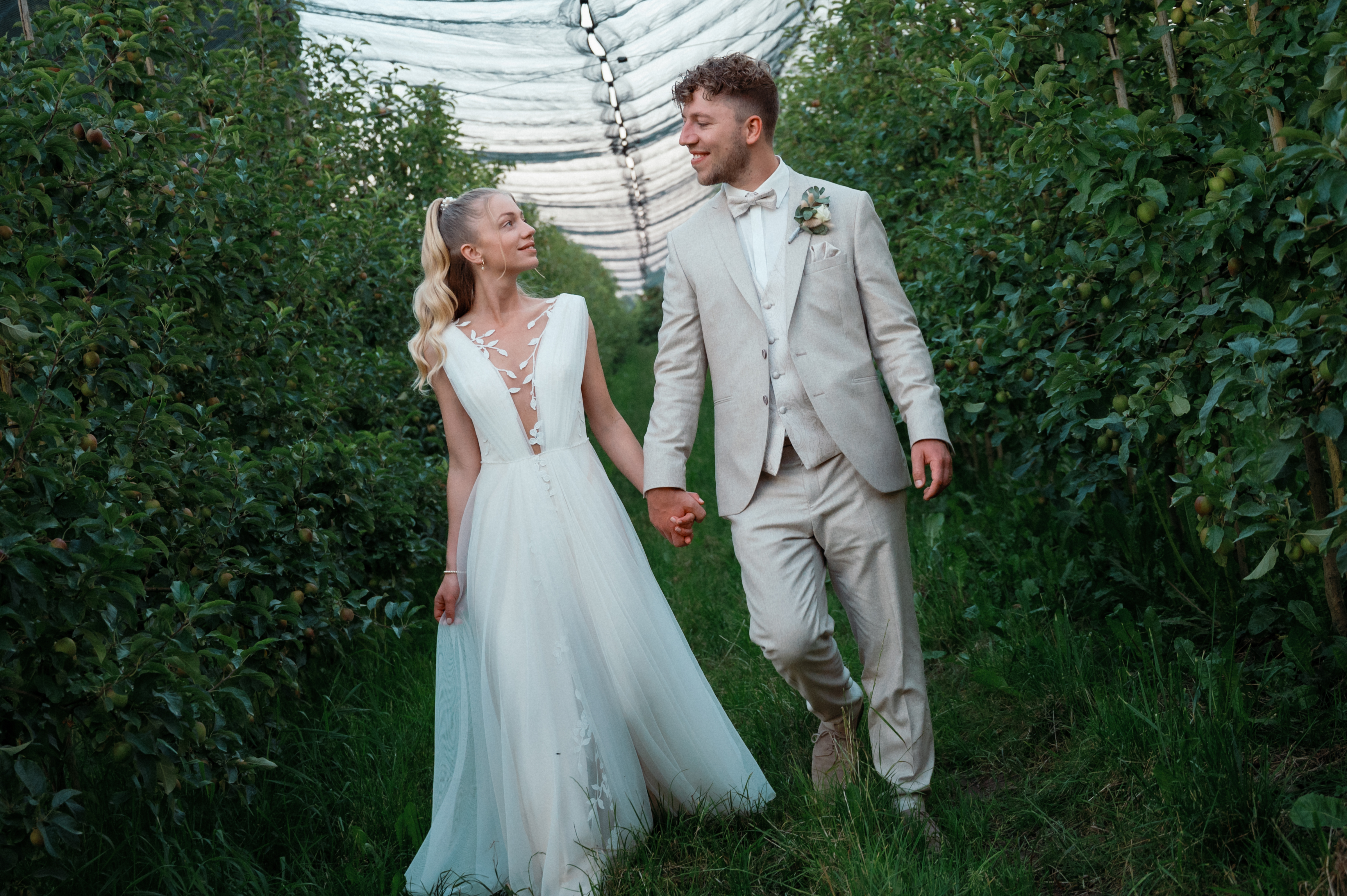 Hochzeitsfotograf - Natürliches Brautpaarfoto zwischen grünen Obstbäumen – Hochzeitsfotografie von Tobias Paul. - Hochzeitsfotografie Tobias Paul