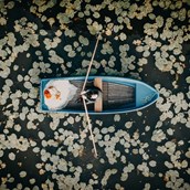 Hochzeitsfotograf: Paarshooting auf einem Boot mitten in einem Seerosenfeld. Das Aftershooting mit dem Brautpaar wurde mit einer Drohne aus der Luft aufgenommen. - Fotograf David Kohlruss