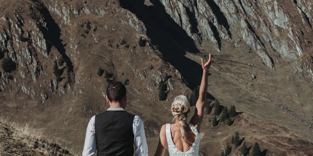 Hochzeitsfotos - Art des Shootings: Portrait Hochzeitsshooting - Oberreute - Braut wirft Brautstrauß in die Luft bei dem Paarshooting in den Kitzbüheler Alpen - Sophia Eerden