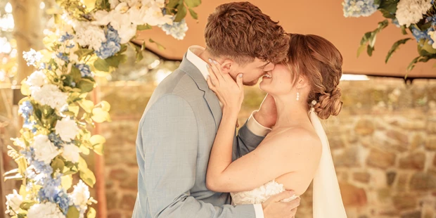 Hochzeitsfotos - Kerpen (Rhein-Erft-Kreis) - Brautpaar küsst sich bei der Freien Trauung nach dem Ja-Wort - abcweddingstories