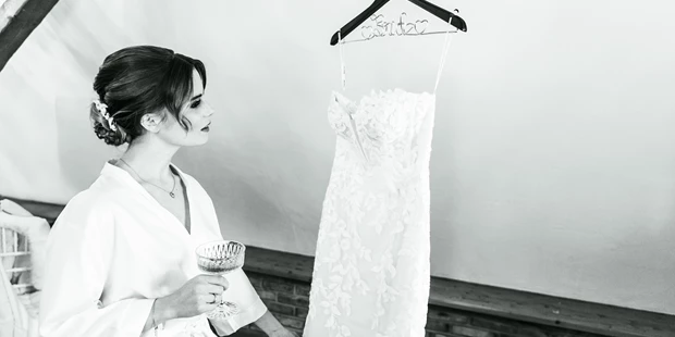 Hochzeitsfotos - Kerpen (Rhein-Erft-Kreis) - Braut schaut ihr Brautkleid an beim Getting Ready Shooting - abcweddingstories