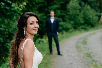 Hochzeitsfotograf: Braut mit Bräutigam im Hintergrund auf der Maierl-Alm in Kirchberg. WE WILL WEDDINGS | Hochzeitsfotografin Tirol / Wien - WE WILL WEDDINGS