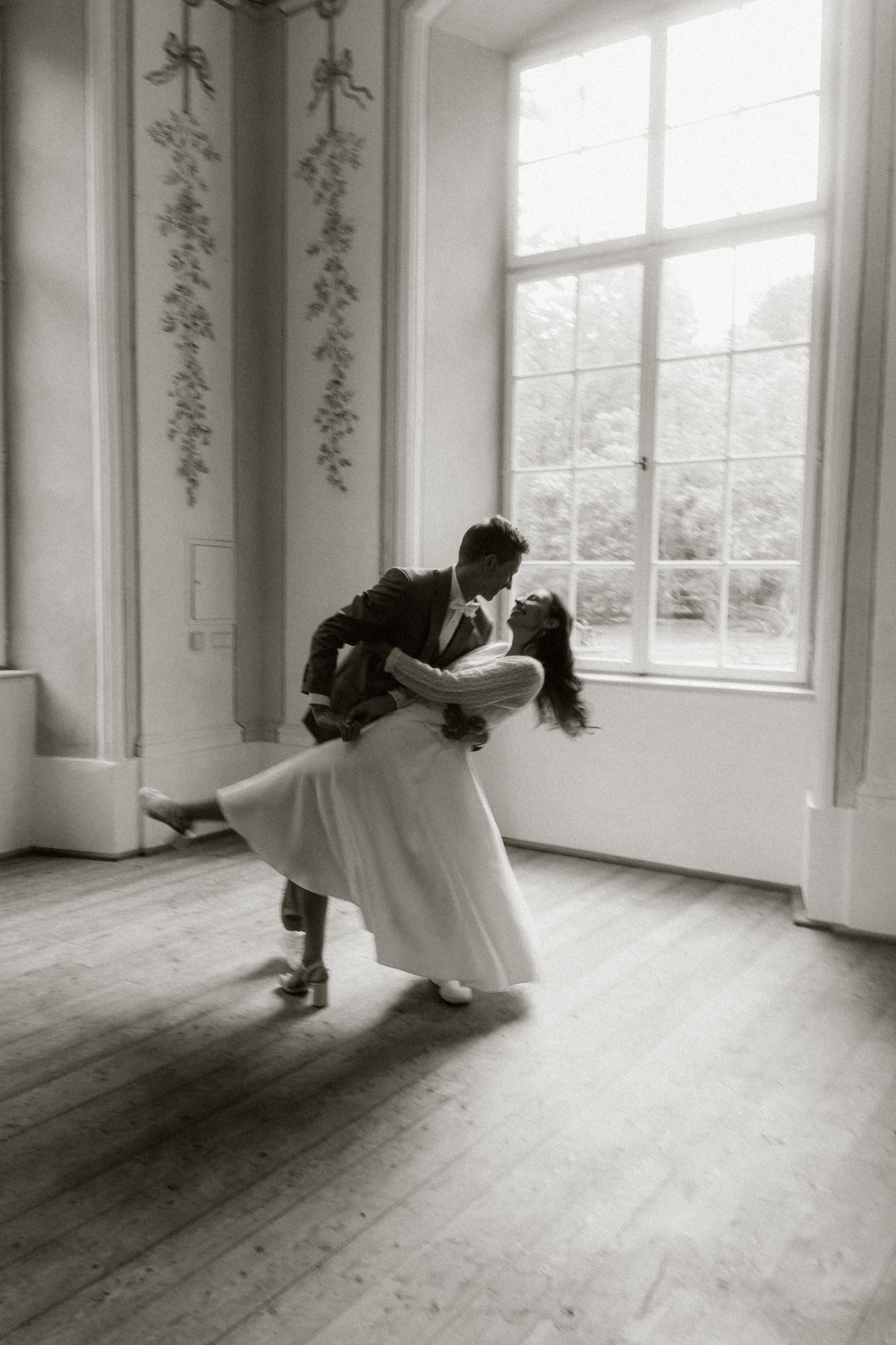 Hochzeitsfotos - Art des Shootings: Fotostory - Tiroler Unterland - Brautpaar in einem Gebäude tanzend in Innsbruck bei einem Hochzeitsshooting fotografiert von moozart - moo-zart