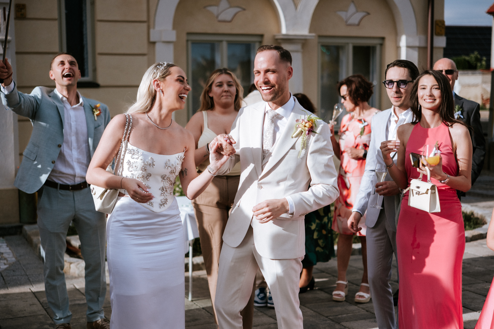 Hochzeitsfotograf: Brautpaar beim Auszug, Gäste jubeln, vor dem Alten Rathaus Wiener Neudorf - Pengoo Weddings