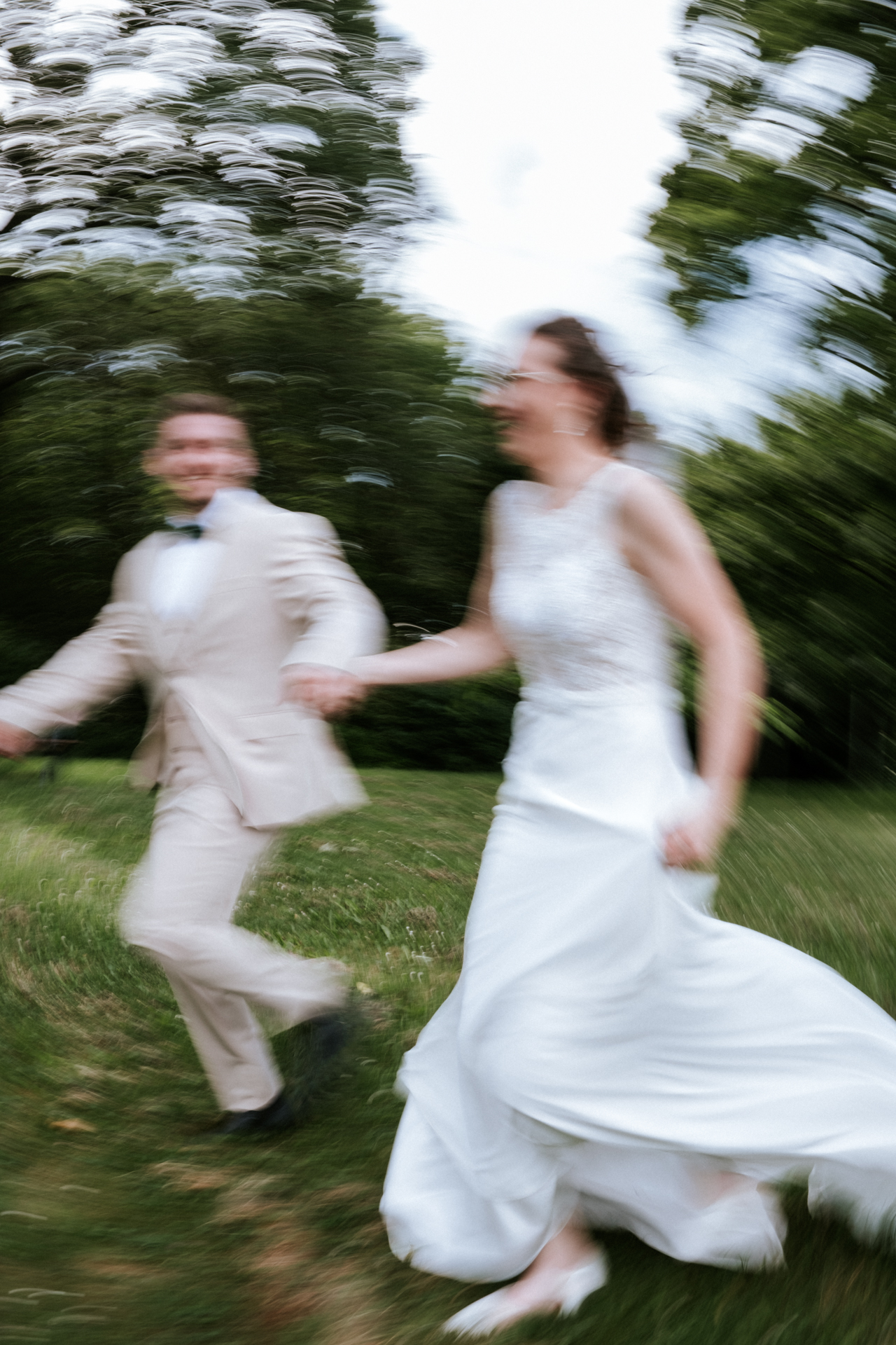 Hochzeitsfotograf: Brautpaar läuft lachend Hand in Hand über die Wiese am Kahlenberg in Wien - Pengoo Weddings