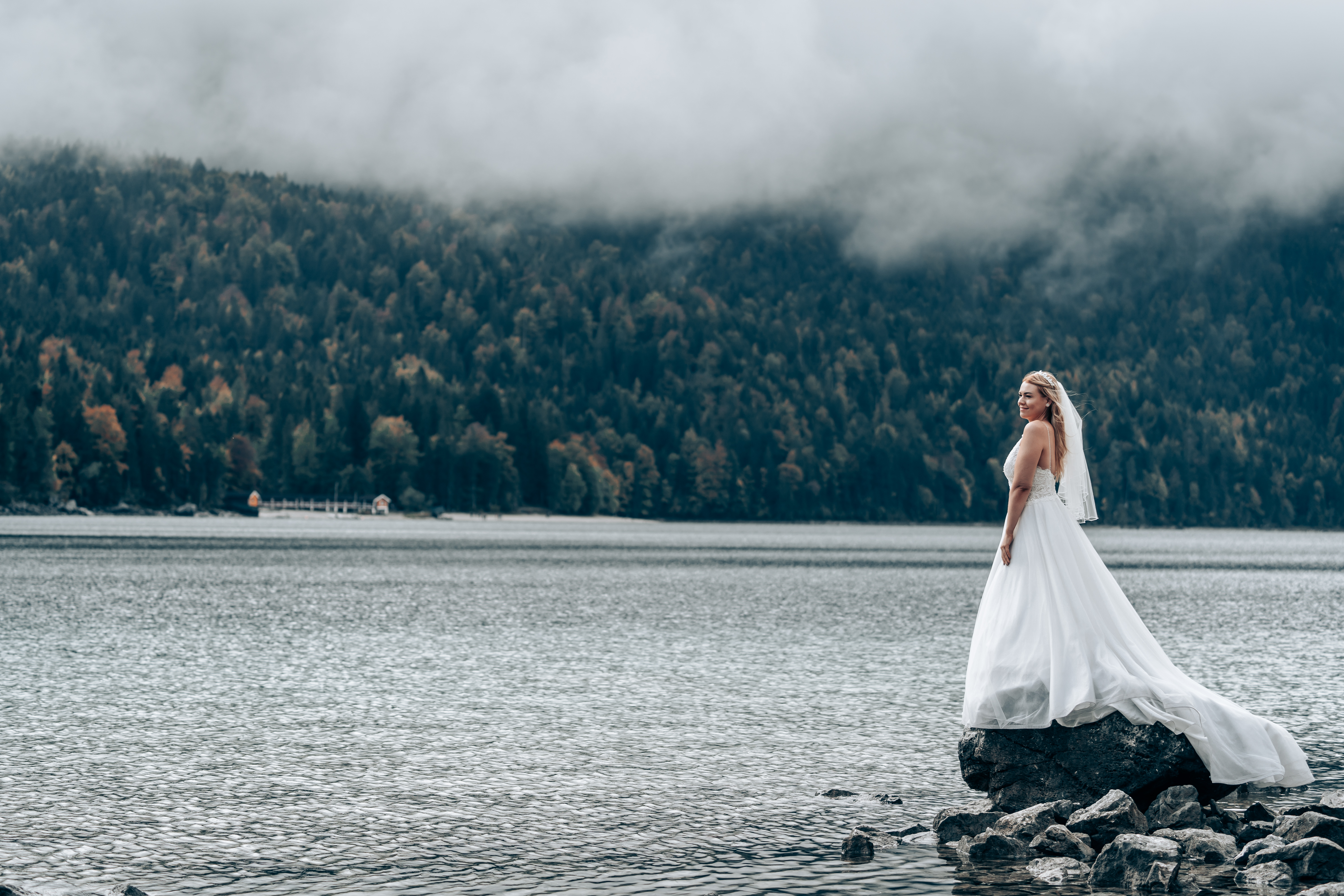 Hochzeitsfotos - Berufsfotograf - Jenbach - Braut steht am See bei schöner Stimmung in weißem Kleid. - Jones de Rosso