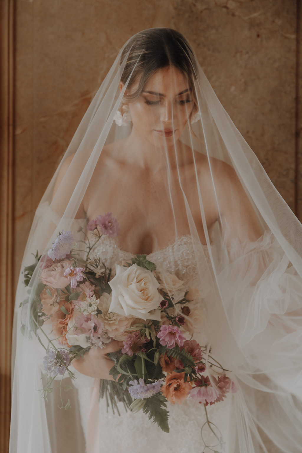 Hochzeitsfotos - PLZ 12524 (Deutschland) - Ein wundervolles Portrait von einer Braut mit einem einzigartigen Schleier. Sie hält einen farbenfrohen Brautstrauss in den Händen und lässt sich von der Fotografin aus Berlin, Maria, in der Normandie, in einem Schloss ablichten. - Lensofbeauty