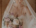 Hochzeitsfotograf: Ein wundervolles Portrait von einer Braut mit einem einzigartigen Schleier. Sie hält einen farbenfrohen Brautstrauss in den Händen und lässt sich von der Fotografin aus Berlin, Maria, in der Normandie, in einem Schloss ablichten. - Lensofbeauty