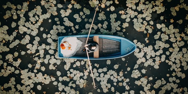 Hochzeitsfotos - Art des Shootings: Fotostory - Deutschland - Paarshooting auf einem Boot mitten in einem Seerosenfeld. Das Aftershooting mit dem Brautpaar wurde mit einer Drohne aus der Luft aufgenommen. - Fotograf David Kohlruss