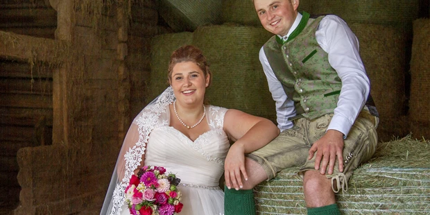 Hochzeitsfotos - Fotostudio - Schladming-Dachstein - Traumhochzeit trotz Regenwetter. Gemma halt in den Heustadel fotografieren. FotoTOM hielt Bernadette&Andreas aus Michaelerberg am Heuballen im Bild fest. - TOM Eitzinger