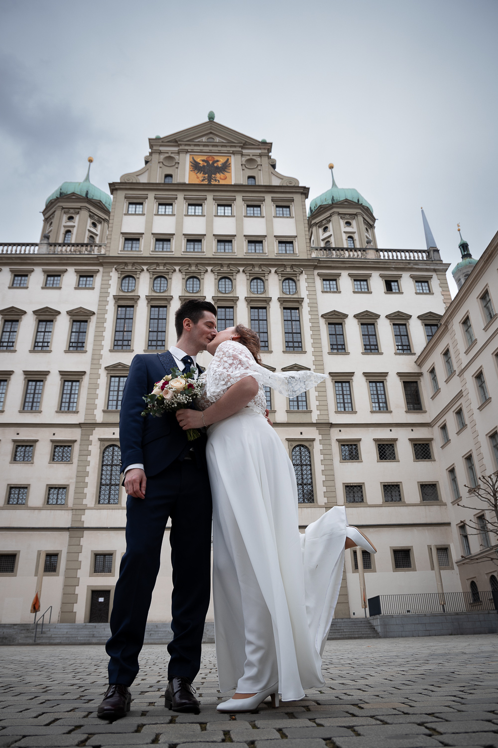 Hochzeitsfotos - Art des Shootings: Prewedding Shooting - Mellau - Das Brautpaar umarmt sich vor einem historischen Gebäude bei einem Hochzeitsshooting in der Stadt. - Zammgfasst