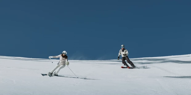 Hochzeitsfotos - Art des Shootings: Hochzeits Shooting - Appenzell - Braut und Bräutigam fahren eine Skipiste runter auf ihren Winterhochzeit. - Sophia Eerden