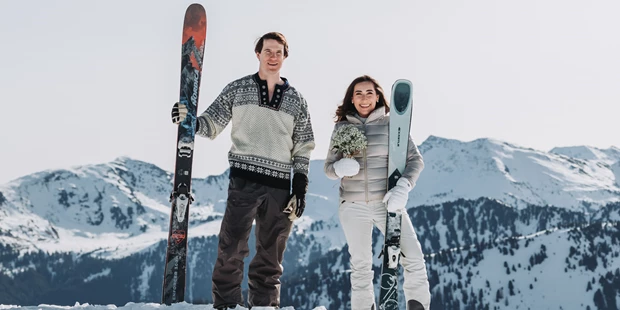 Hochzeitsfotos - Art des Shootings: Hochzeits Shooting - Appenzell - Braut und Bräutigam stehen mit ihren Skiern in der Hand im Schnee und genießen das Paarshooting am Berg. - Sophia Eerden