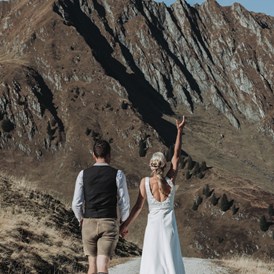 Hochzeitsfotograf: Braut wirft Brautstrauß in die Luft bei dem Paarshooting in den Kitzbüheler Alpen - Sophia Eerden