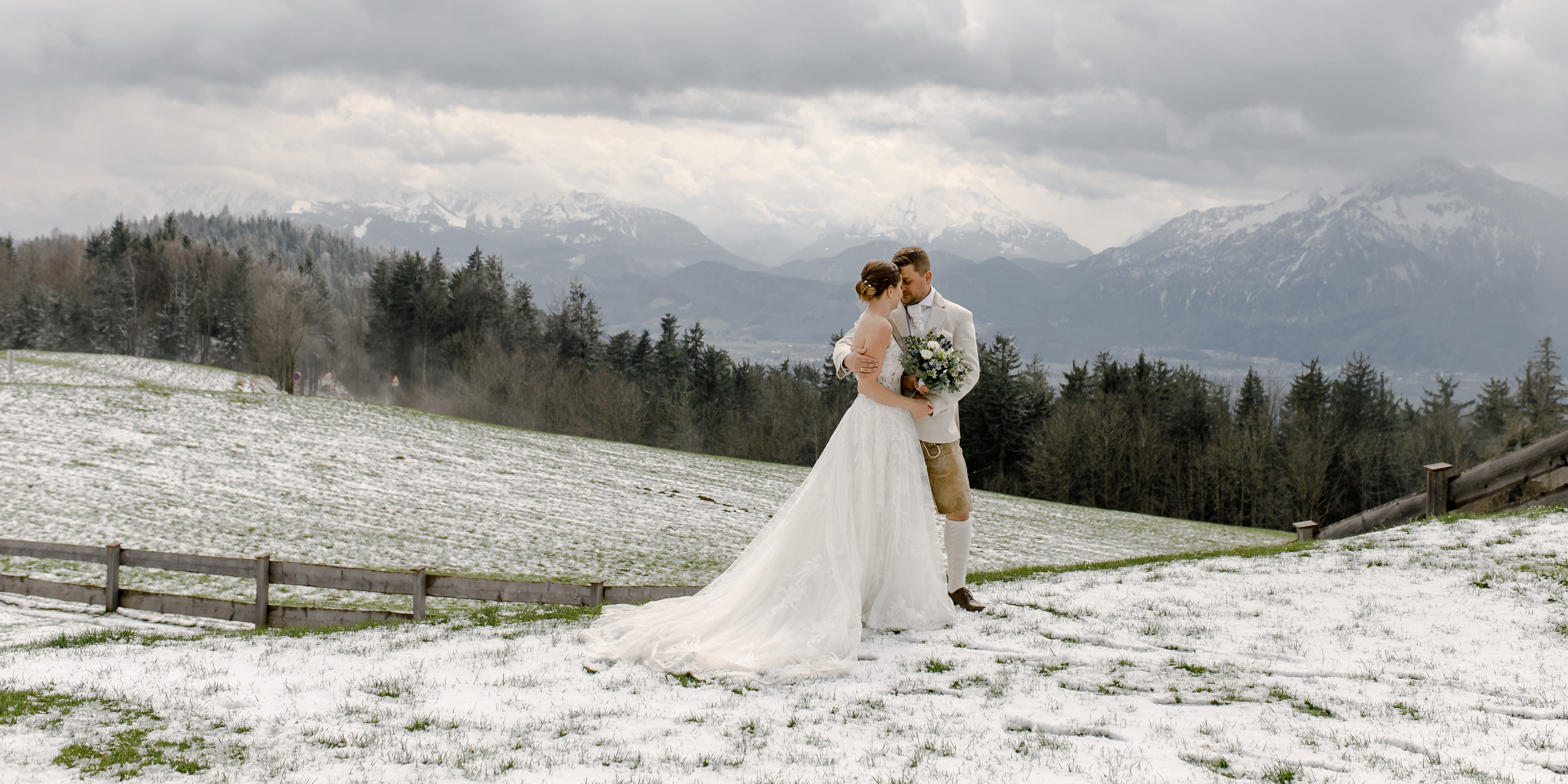 Hochzeitsfotos - Berufsfotograf - Sankt Georgen bei Salzburg - ein verliebtes Paar inmitten der Berge. Die Braut trägt ein wunderschönes Hochzeitsreise-Kleid, während der Bräutigam in Tracht gekleidet ist. Die natürliche Umgebung bietet eine atemberaubende Kulisse für dieses Paar-Foto und lässt die Liebe des Paares erstrahlen - Tatiana Ebel Hochzeitsfotograf, Salzburg